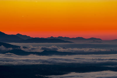 Scenic view of dramatic sky over landscape during sunset