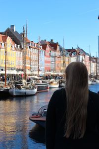 Rear view of woman by canal in city