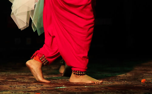 Low section of woman standing on field