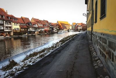 Road amidst houses in town against clear sky