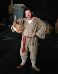 Portrait of man holding camera while standing at home