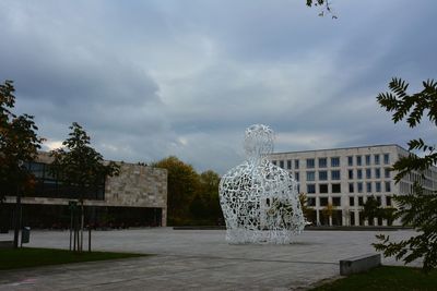 Fountain by building against sky