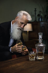 Side view of senior man sitting on table