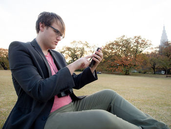 Side view of young man using mobile phone
