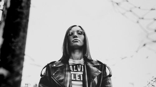 Low angle portrait of man standing against sky