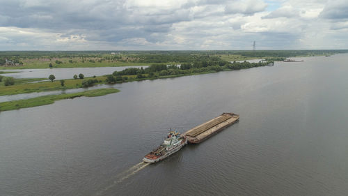 Barge with cargo on the river volga. river tugboat moves cargo barge, cargo ship on the river.