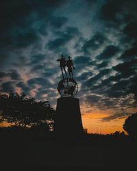 Low angle view of silhouette statue against sky during sunset