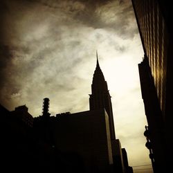 Low angle view of buildings against cloudy sky