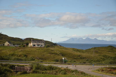 Houses by sea against sky