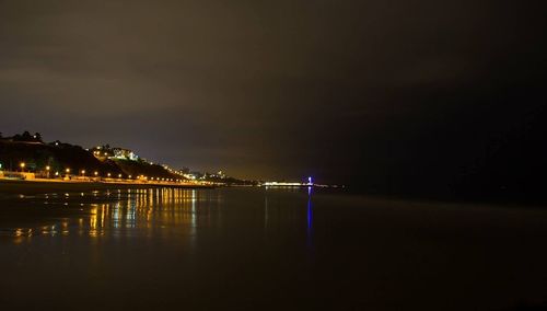 Illuminated sea against sky at night