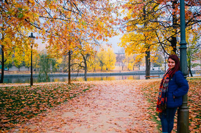 Woman standing by trees during autumn