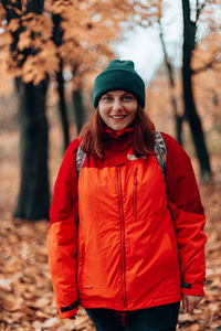 Portrait of young man standing in forest during winter