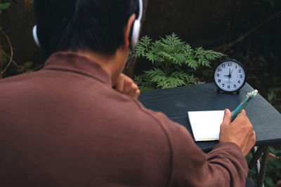 Rear view of man holding book
