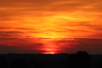 Scenic view of silhouette landscape against orange sky