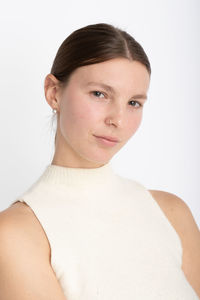 Portrait of young woman against white background