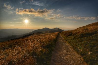 Road amidst landscape against sky during sunset