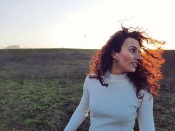 Young woman standing against sky