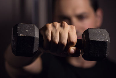 Close-up of man lifting dumbbell