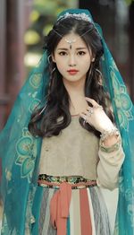 Portrait of young woman standing against temple