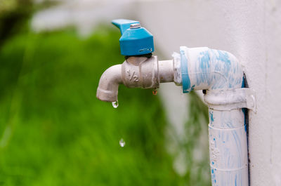 Close-up of water drop dripping from faucet