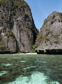 Rock formation by sea against sky