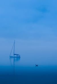 Sailboat in sea against blue sky