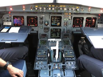 Midsection of people sitting in airplane cockpit
