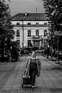 Rear view of man sitting on street in city