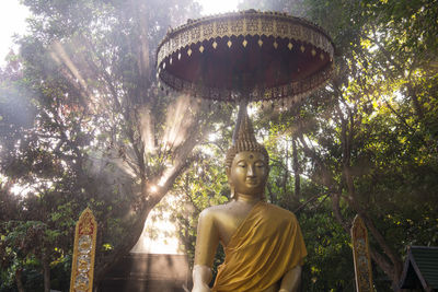 Low angle view of statue against trees