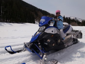 Low angle view of girl riding motorcycle on snow
