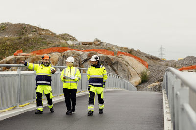 Engineers in reflective clothing walking on bridge