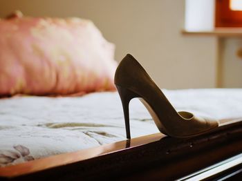 Close-up of high heel on bed at home