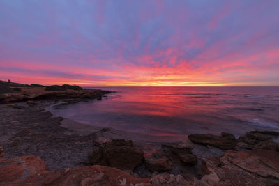 Scenic view of sea against romantic sky at sunset