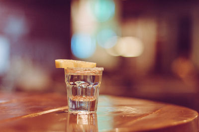 Close-up of lemon slice with drink on table