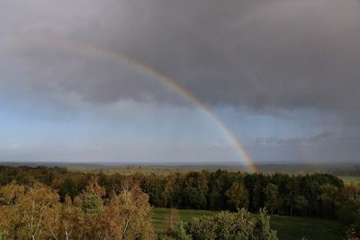 Scenic view of rainbow over landscape against sky