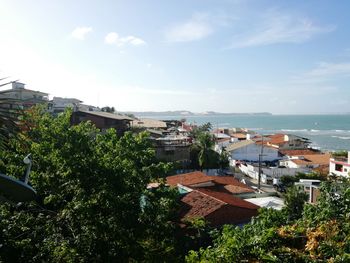 Houses by sea against sky in city