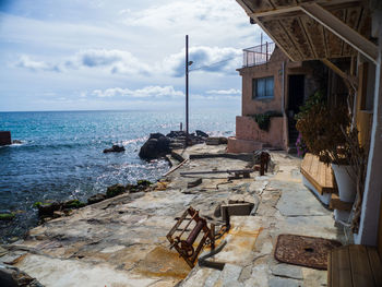 Built structure on beach by sea against sky