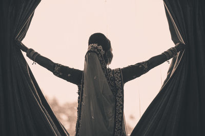 Rear view of woman standing in tent
