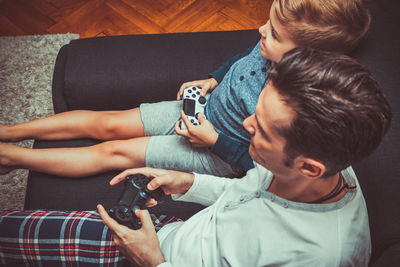 Father and son playing video game at home