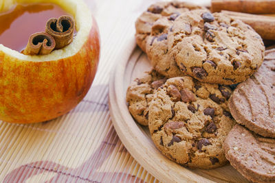 Close-up of apple and cookies with chocolates on table