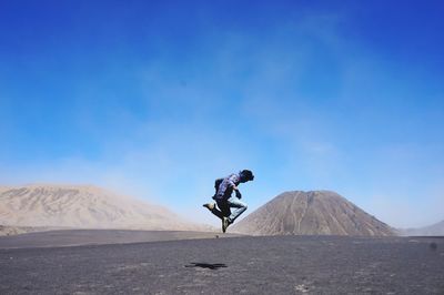 Man on arid landscape against sky