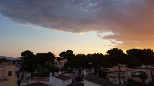 Buildings against cloudy sky at sunset