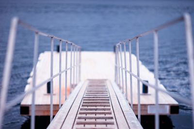 Close-up of railing by sea against sky