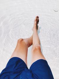 Low section of man relaxing in swimming pool