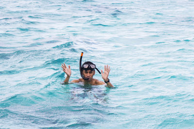 Portrait of shirtless man snorkeling in sea