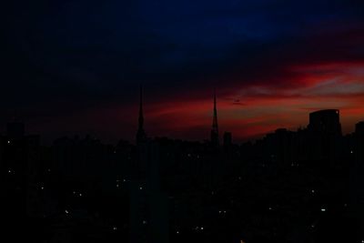 Silhouette buildings against sky at night