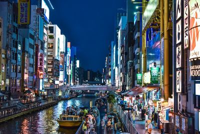 Panoramic view of illuminated buildings by street in city at night