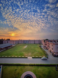 High angle view of road by buildings against sky during sunset