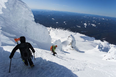 Two men climb down from the summit of mt. hood in oregon.