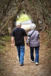 Rear view of people walking in forest